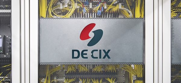 un panel de conexiones con muchos cables amarillos y el cartel de DE-CIX