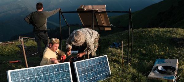 two men working on a solar panel